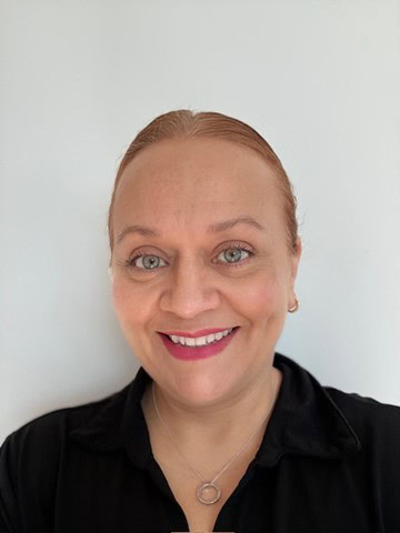 Professional portrait of Gabriela Chavez, NAHMA member and housing expert, smiling against a plain b.