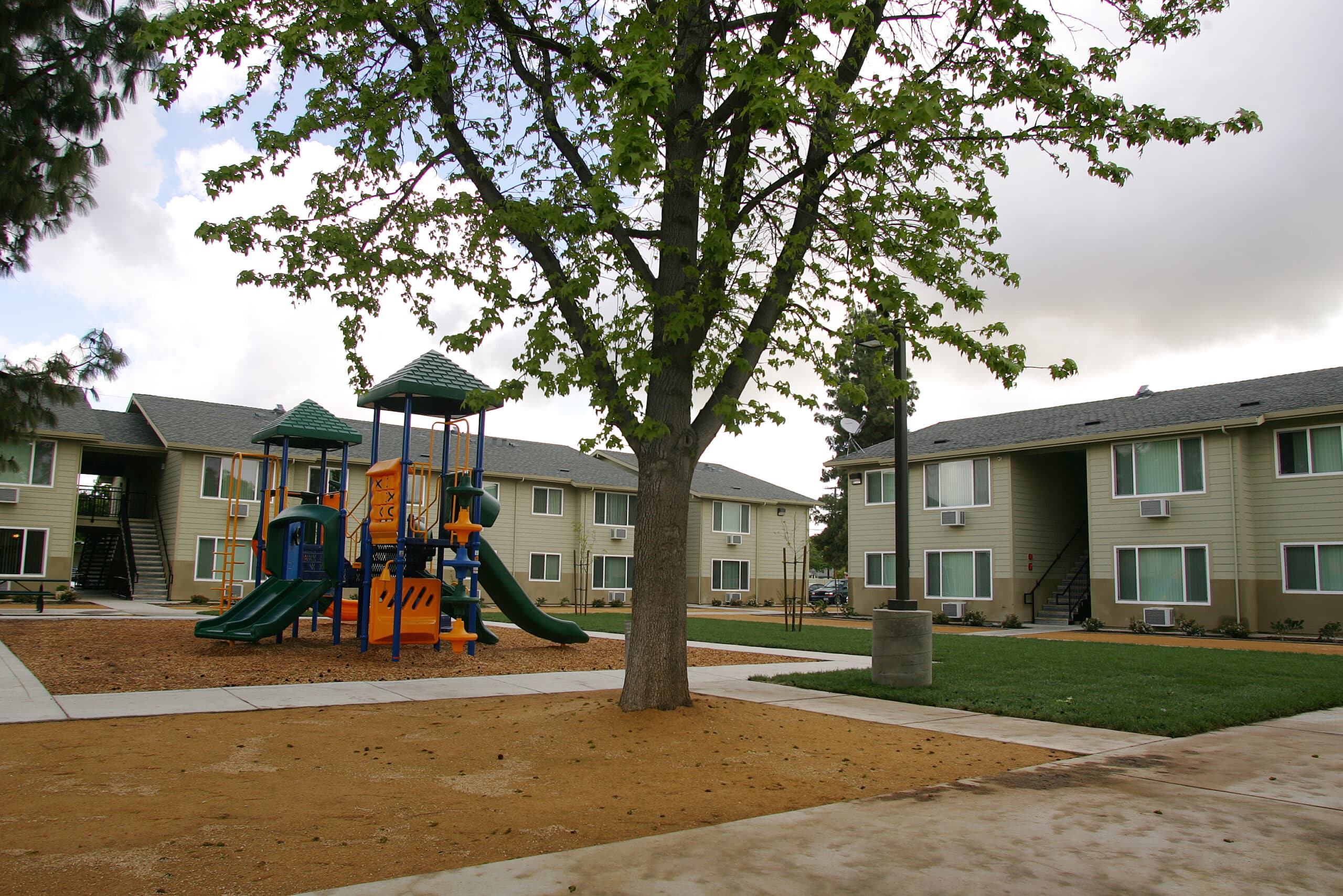 A colorful playground with slides and climbing structures in a residential apartment complex.